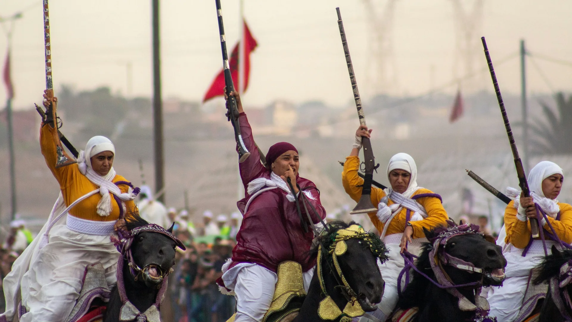 Moroccan horsemen firing rifles in unison during a Fantasia (tbourida) charge